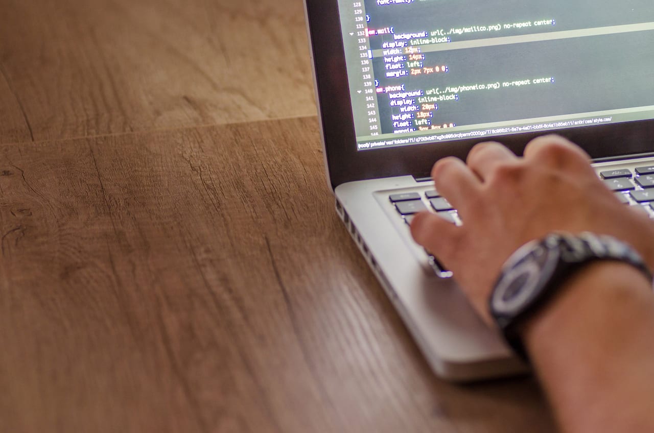 Person updating website code on a laptop